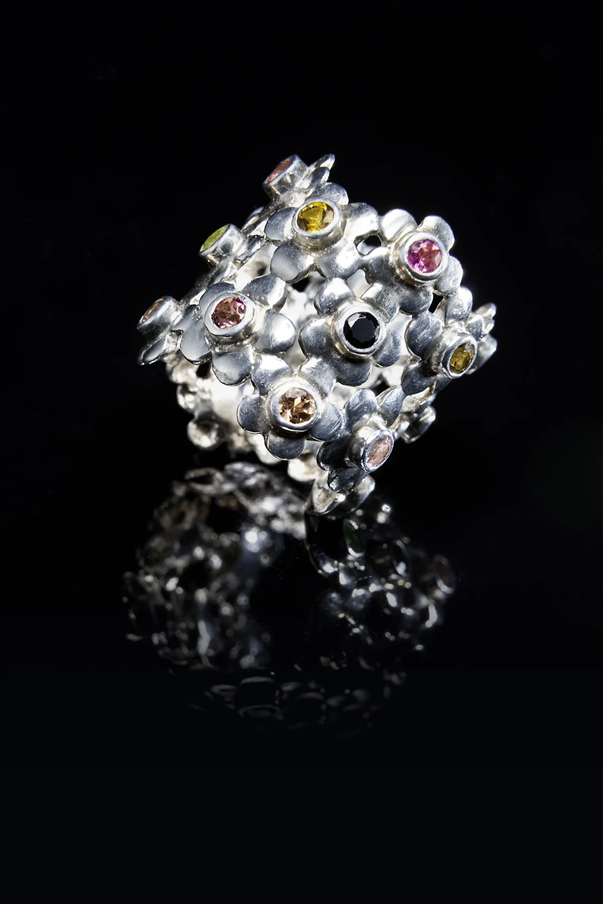 Bague sculpturale Spinelle ornée d’un assemblage de pierres lumineuses sur fond noir